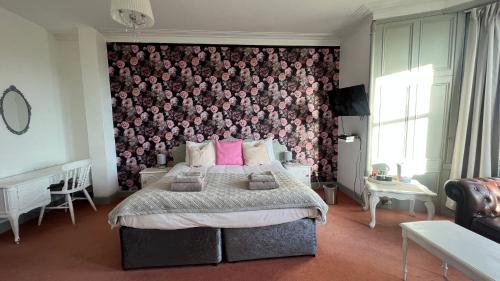 a bedroom with a bed with a floral wall at Hotel Square in Tomintoul