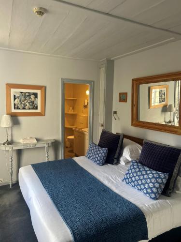 a bedroom with a large bed with blue pillows at La Baronnie Hôtel & Spa - Teritoria in Saint-Martin-de-Ré