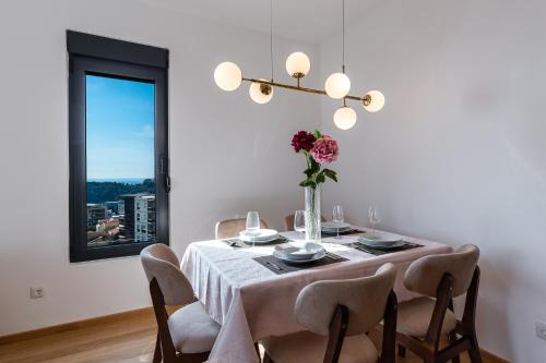 a dining room table with a vase of flowers on it at TRE Apartments in Becici