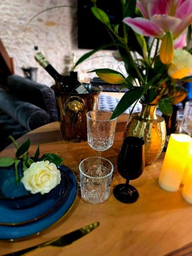 une table avec des assiettes bleues et un vase avec des fleurs dans l'établissement Le Royal Love Loft, à Reignac
