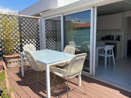 une table et des chaises sur une terrasse avec une cuisine dans l'établissement Lumineux top terrasse 2P, à Cannes