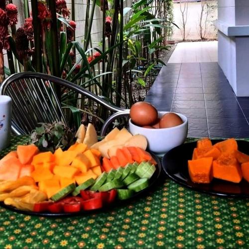 two plates of fruit and vegetables on a table at CHILLI's Homes2 in Chiang Mai