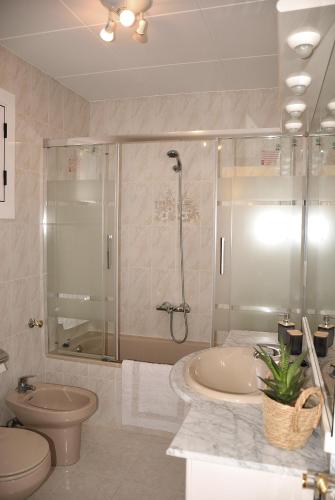 a bathroom with a shower and a toilet and a tub at Can Teixidó in Arbeca