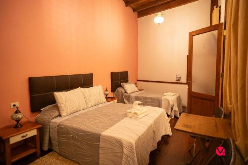 a bedroom with two beds and a mirror at ALOJAMIENTOS NECANA in Icod de los Vinos