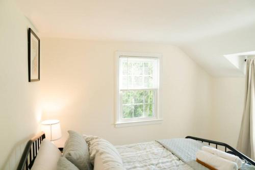 a white bedroom with a bed and a window at Charming & Cozy 3BR home mins to SU-ESF-Upstate-Le Moyne in Syracuse