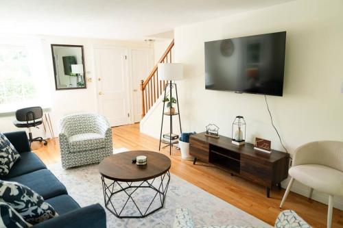 a living room with a blue couch and a tv at Charming & Cozy 3BR home mins to SU-ESF-Upstate-Le Moyne in Syracuse