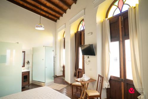 a bedroom with a bed and a table and chairs at ALOJAMIENTOS NECANA in Icod de los Vinos