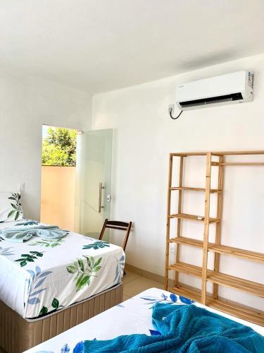 a room with two beds and a ladder and a window at Ilha de Boipeba kitnets para temporada - Morada dos Pássaros Boipeba in Ilha de Boipeba