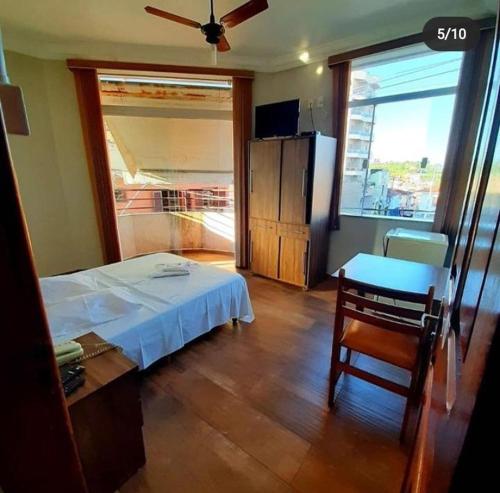 a bedroom with a bed and a table and a window at Colinas Hotel in Machado