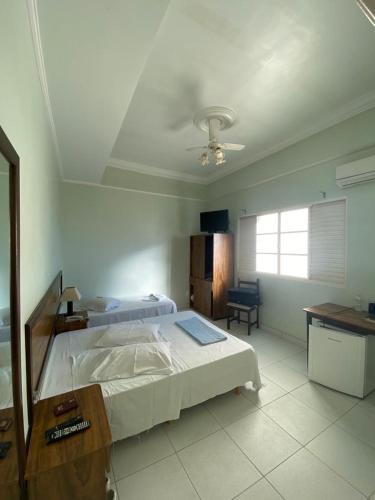 a bedroom with a bed and a ceiling fan at Colinas Hotel in Machado