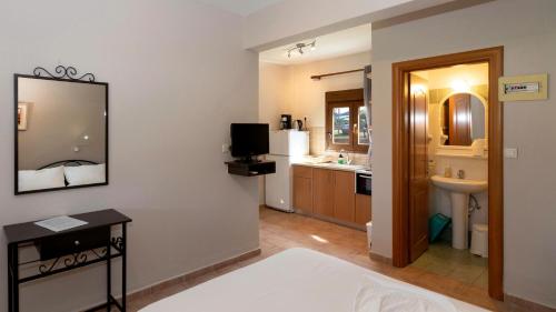 a bathroom with a bed and a sink and a mirror at Katerina-Maria Studios & Apartments in Vourvourou