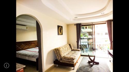a bedroom with a bed and a chair and a window at Junior apartment in Pattaya