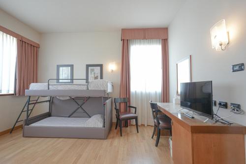 a bedroom with a bunk bed and a desk with a computer at Hotel Europa in Reggio Emilia