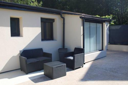 deux chaises et une table sur une terrasse dans l'établissement La Cachette du Bonheur, à Cély-en-Bière