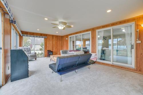 a living room with a couch and a ceiling fan at Lakefront Home with Deck and Dock in Oscoda Twp! in Lincoln Junction