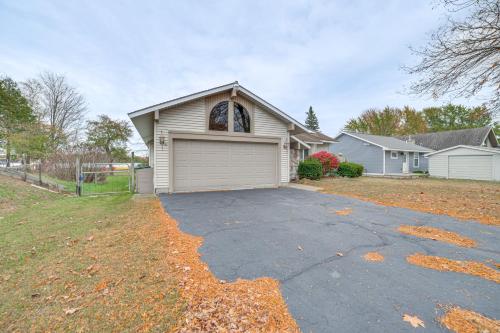 a house with a garage in a yard at Lakefront Home with Deck and Dock in Oscoda Twp! in Lincoln Junction