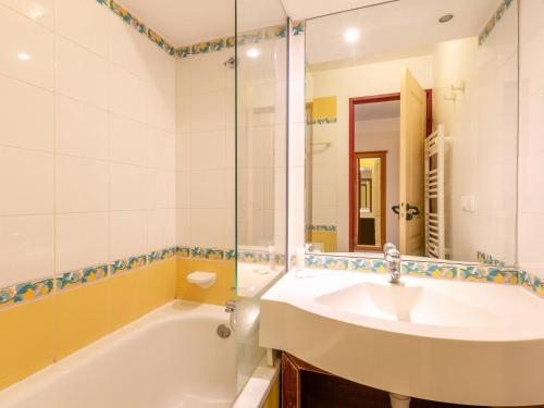 une salle de bain avec un lavabo, une baignoire et un miroir dans l'établissement La Plagne, 5 pers, balcon, animaux admis - FR-1-353-115, à La Plagne Tarentaise