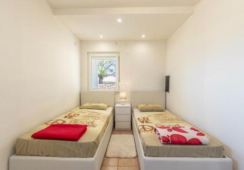 a bedroom with two beds and a window at House Dali in Ražanac