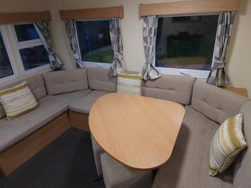 a living room with a table and a couch at 3 bedroom caravan 14 kingsgate in Shanklin