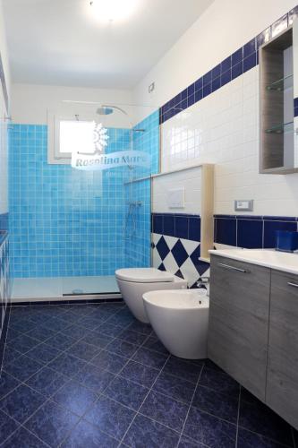 a blue and white bathroom with two toilets and a sink at Elsa bilocale vista spiaggia in Rosolina Mare