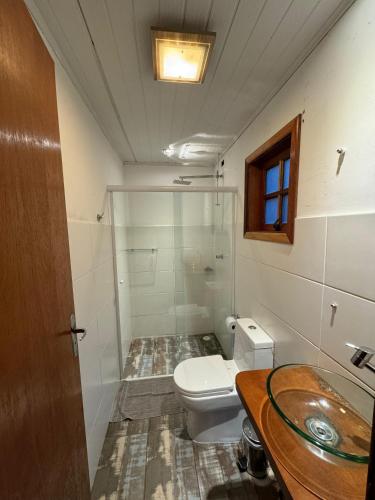 a bathroom with a toilet and a sink at Refúgio dos Platanus in Campos do Jordão