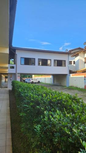 a white building with a car parked in front of it at Apto Duplex com Mezanino in Juquei