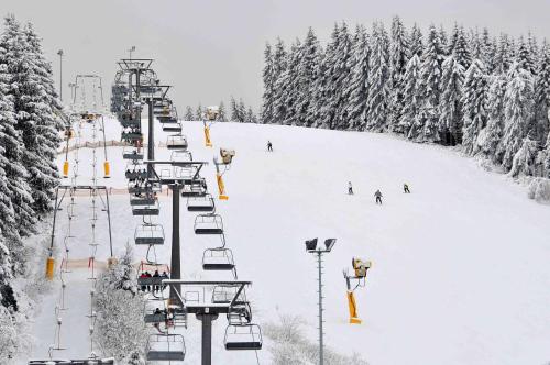 a ski lift with people skiing down a snow covered slope at Hotel Niedersfeld-Winterberg in Winterberg