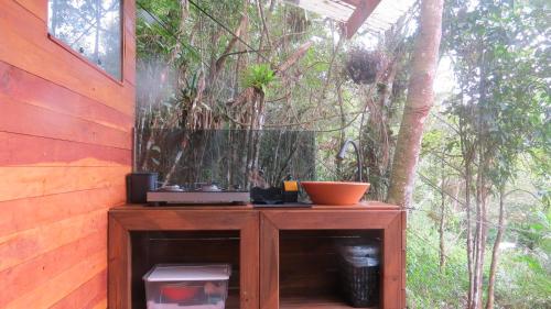 a wooden table with a fish tank in a garden at Cabanas sítio Ancestral in Morretes