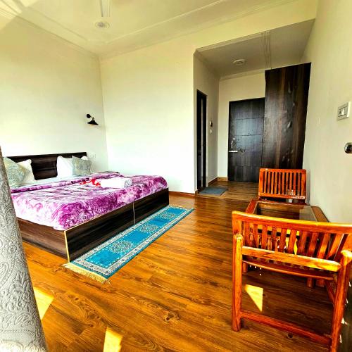 a bedroom with a bed and a wooden floor at Hana Resort Landing Site in Bīr