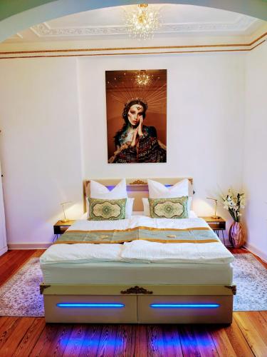 a bedroom with a large bed with a painting on the wall at Exklusive Ferienwohnung Agnes in zentraler Bestlage von Zeitz! Vollausgestattet, freie Parkplätze, Magenta-TV, Highspeed WLAN, Fahrstuhl in Zeitz