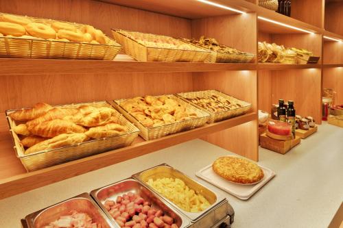 a buffet with many different types of bread and pastries at B&B HOTEL Donostia Aeropuerto in Oiartzun
