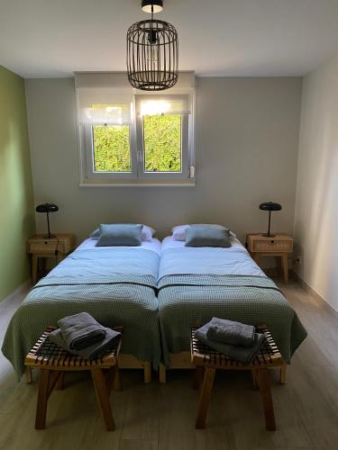 - une chambre avec 2 lits, un lustre et 2 fenêtres dans l'établissement Au chemin des vignes, à Bergheim