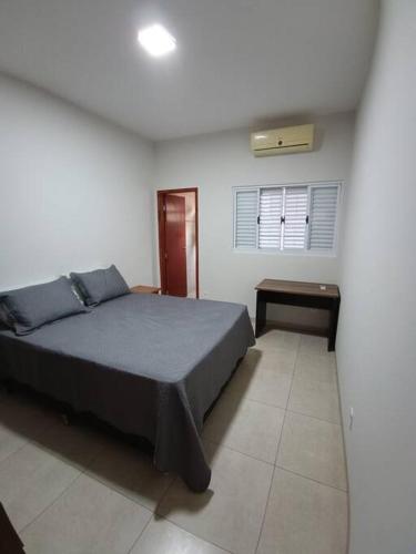 una camera da letto con un letto e una finestra di Aconchego 2 a Dourados