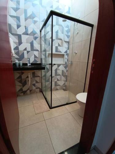 un bagno con doccia in vetro e WC di Aconchego 2 a Dourados