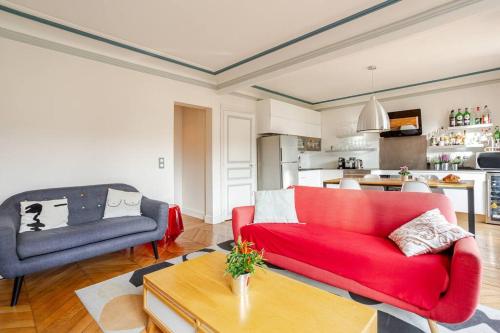 un salon avec un canapé rouge et une cuisine dans l'établissement Lovely Appartment Montmartre - View Sacré coeur, à Paris