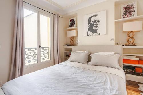 une chambre blanche avec un lit et une fenêtre dans l'établissement Lovely Appartment Montmartre - View Sacré coeur, à Paris
