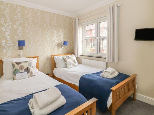 a room with two beds and a window at 4 Victoria Court in Sheringham