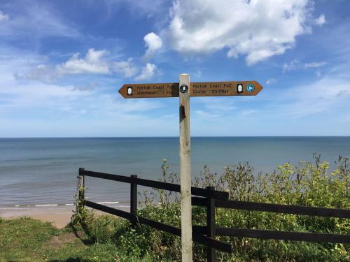 a wooden sign on the side of a beach at 4 Victoria Court in Sheringham