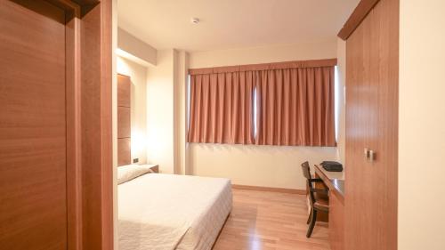 a hotel room with a bed and a desk at Hotel Europa in Reggio Emilia