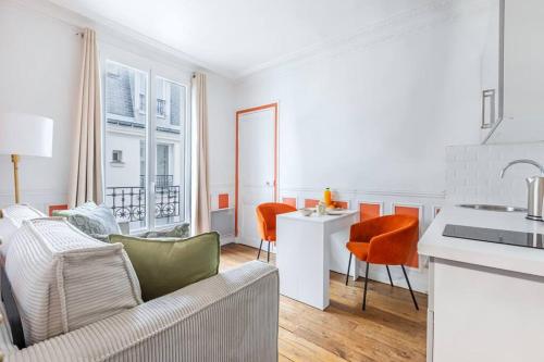 Il comprend un salon blanc avec un canapé et une cuisine. dans l'établissement Appartement Coloré et Lumineux à Paris, à Paris