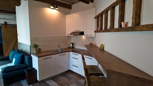 a kitchen with white cabinets and a blue couch at Apartman Vulcano in Zvolen
