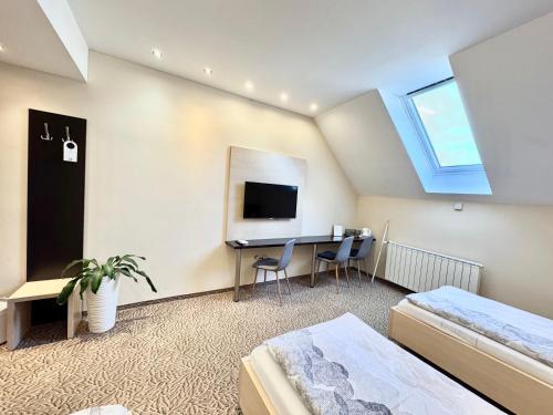 a bedroom with a desk and a tv in a room at Hotel Zlaté Košice - Self reception in Košice