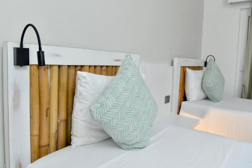 a bed with a green and white pillow on it at Honky Tonk Colonial in Santo Domingo