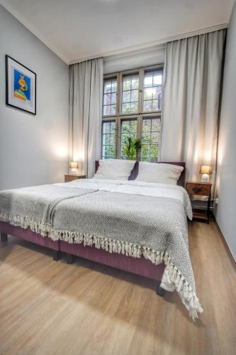 a bedroom with a large bed and a window at Happy Street OLD TOWN 24-hour Reception in Toruń