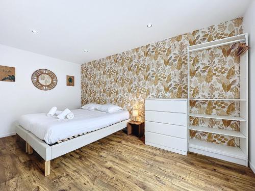 une chambre avec un lit et une peinture murale dans l'établissement Appartement cosy & moderne T2 avec jardin parking, à Brest