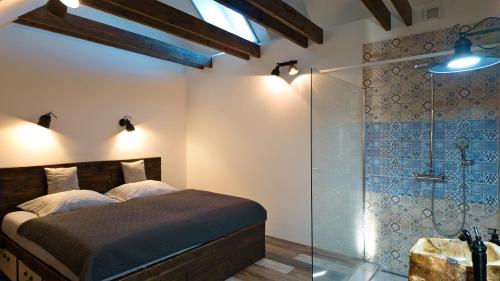 a bedroom with a bed and a glass shower at Apartman Vulcano in Zvolen