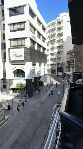 a city street with people walking in front of a building at Sea Breeze Retreat - Comfort Apartments in the Heart of Sliema in Sliema