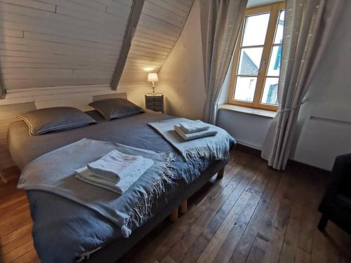 une chambre avec un grand lit avec deux serviettes dessus dans l'établissement Ty Plouz Rospico, à Névez