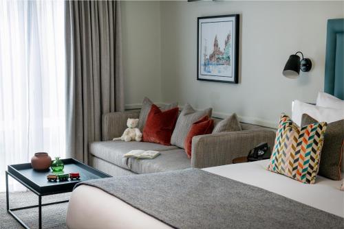 a living room with a couch and a living room with a couch at Thorpe Park Hotel and Spa in Leeds