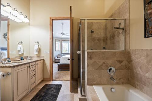 a bathroom with a shower and a tub and a sink at Spacious Retreat, Sleeps 7, Minutes to Skiing, Private Hot Tub, Scenic Views, Ultimate Relaxation! in Park City
